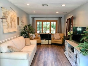 A living room with a sofa, TV, and a wooden cabinet.