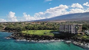A coastal hotel with a view of the ocean and a golf course.