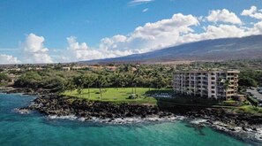 A coastal hotel with a view of the ocean and a golf course.