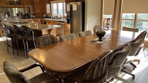 A spacious kitchen with a large island, wooden dining table, and chairs. - Great for Friends & Families, Breathtaking View, Nature Trails, Farm Animals (Millersburg)