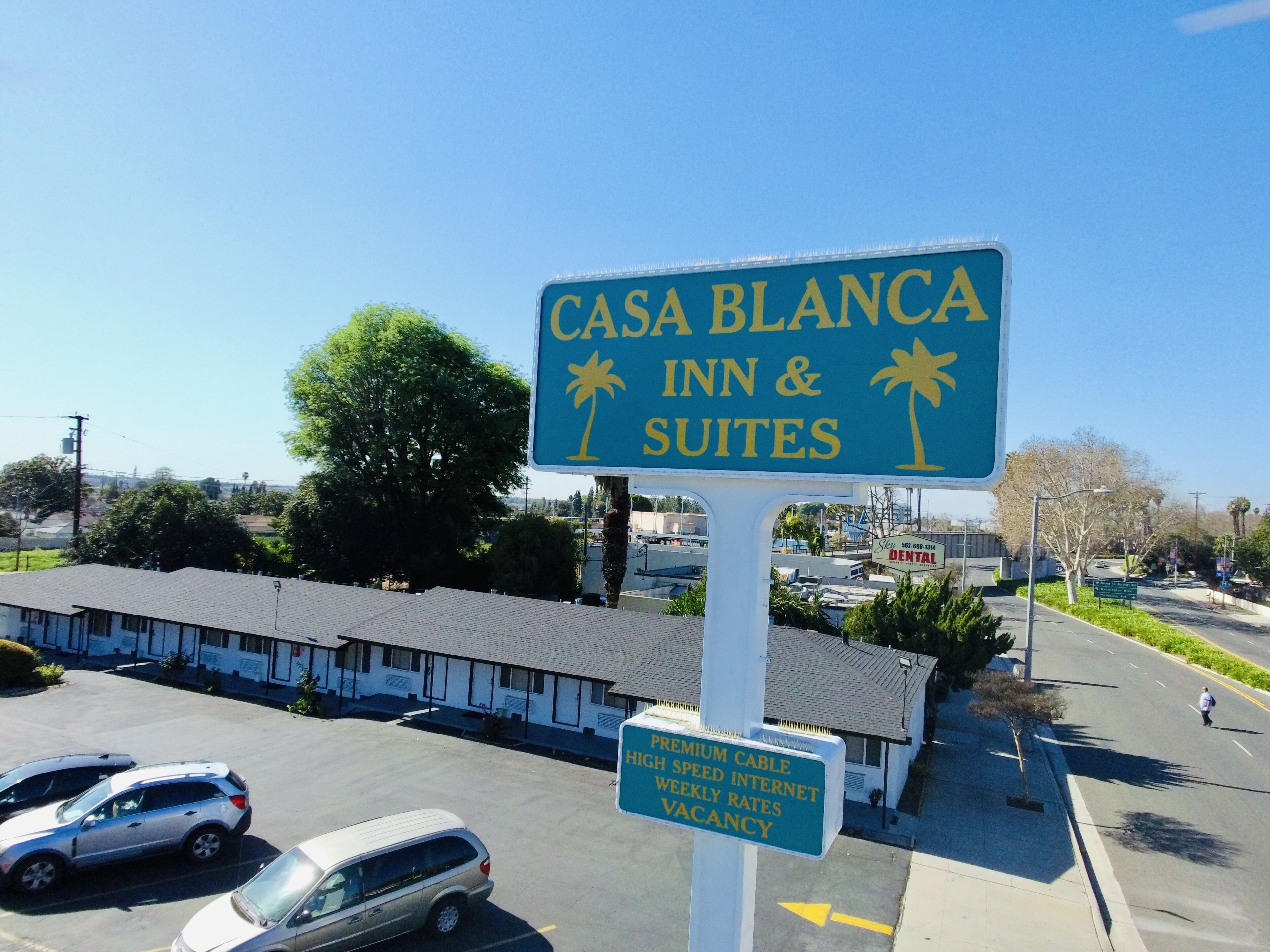 A sign for Casa Blanca Inn & Suites advertising premium cable, high-speed internet, weekly rates, and vacancy.