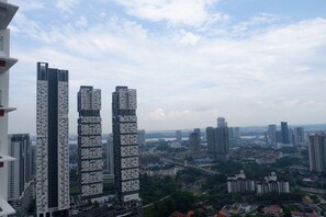 A cityscape with modern high-rise buildings, including a distinctive tower with a checkered pattern.