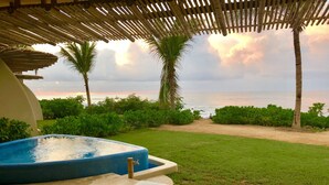 Un espace piscine doté d’un jacuzzi, de chaises longues et offrant une vue sur l’océan.