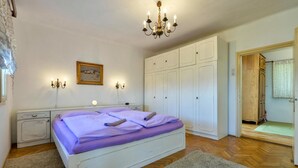 A bedroom with a bed, white wardrobe, and a chandelier. - Luxurious home in Ludbreg (Ludbreg)