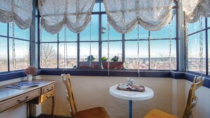 A room with a large window, a wooden desk, a chair, a small table with a cup and saucer, and a view of a cityscape. - Luxurious home in Ludbreg (Ludbreg)