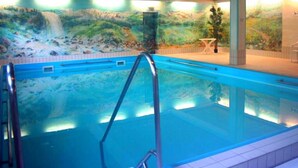 An indoor swimming pool with a mural of a waterfall and greenery on the wall. - Ferienwohnung für 4 Personen, 2 Schlafzimmer mit Balkon, 60 m² (Inzell)