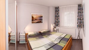 A bedroom with a bed, a desk, a chair, a window with curtains, and a wall-mounted picture. - Ferienwohnung für 4 Personen, 2 Schlafzimmer mit Balkon, 60 m² (Inzell)