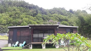 A wooden cabin with a porch, two blue chairs, and a satellite dish. - Le Domaine de Jade Chalet Amélie (saint andre)