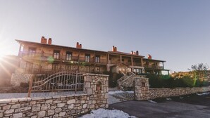 A stone building with a balcony and a staircase leading to a second floor. - Thea Mainalou (Gortynia)