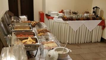 A buffet setup with various food items and utensils.
