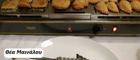 A grill with various pastries and a plate in the foreground.