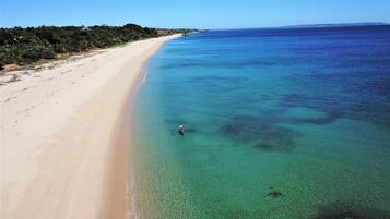 Playa privada, arena blanca, sillas reclinables de playa, sombrillas