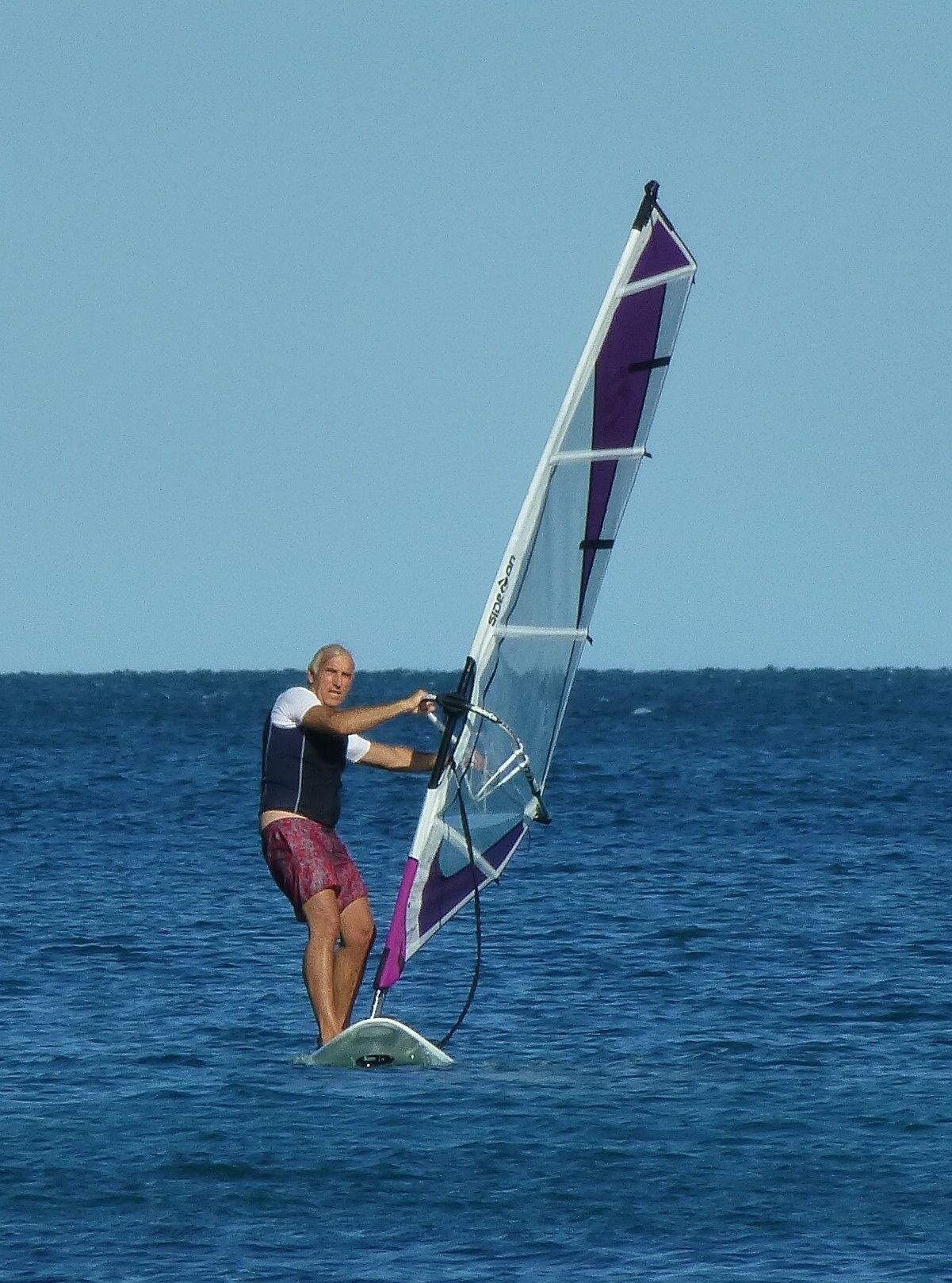 A person windsurfing on a clear day.