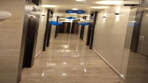 A corridor with a shiny floor, doors on the sides, and blue balloons hanging from the ceiling. - Nu Blue Moon Guest House (Howrah)