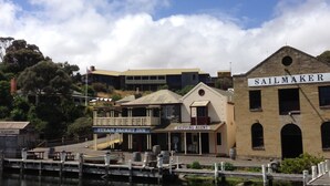 Una zona ribereña con un hostal Steam Packet Inn, una agencia marítima y un taller de tapicería de velas.