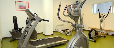 A gym with stationary bikes, treadmills, and a rowing machine.