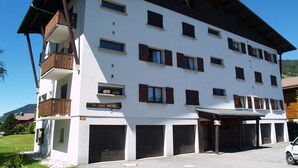 Un edificio de varios pisos con fachada blanca y contraventanas marrones, con balcones y un letrero que dice "le saint MICHEL".
