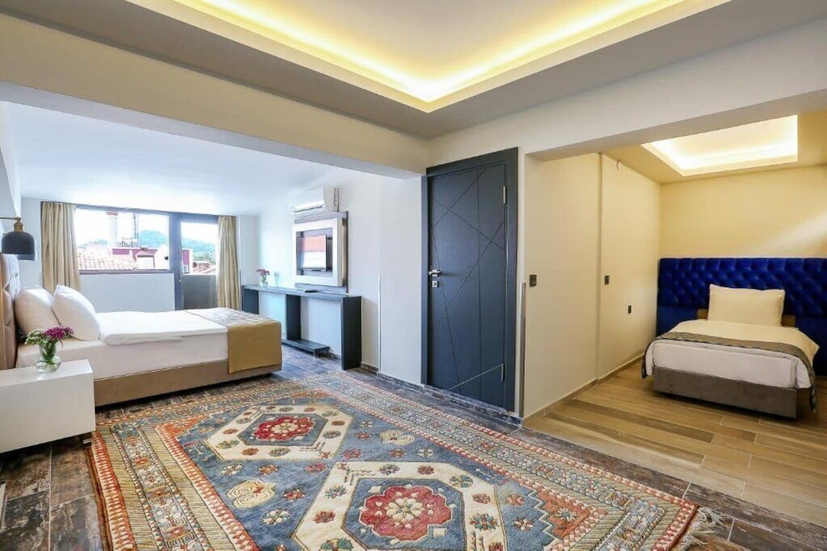 Una habitación de hotel moderna con una cama grande, un sofá, un escritorio y un televisor.
