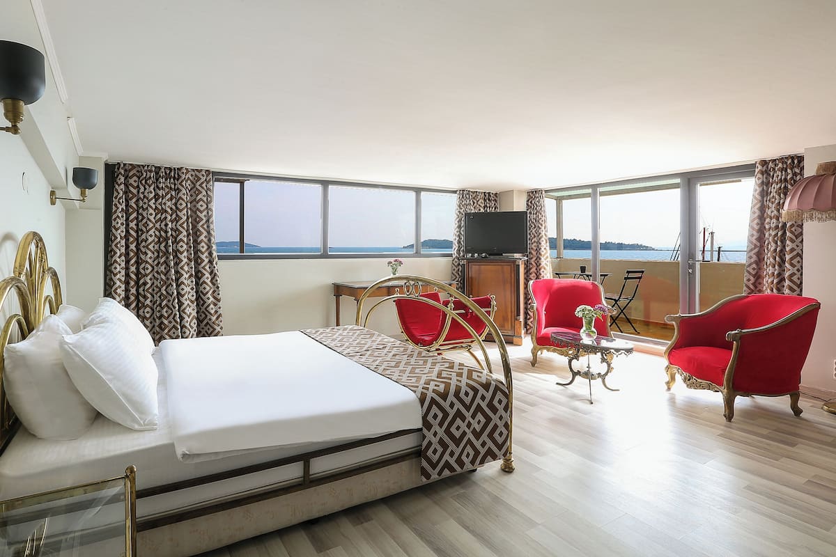 Una habitación de hotel con una cama, televisor, escritorio y una silla.