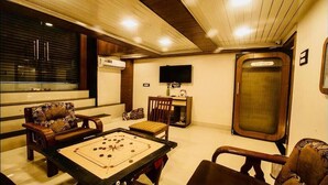 Una habitación con mesa de billar, televisión y un armario de madera.