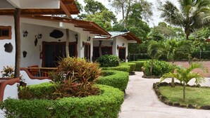 A building with a white exterior, wooden beams, and a covered walkway. - Piedras Blancas Lodge (Bella Vista)
