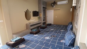A hotel room with a large bed, a TV, a mirror, a wardrobe, and a small table. - Jumbo Villa Homestay and Resort (Wiset Chai Chan)
