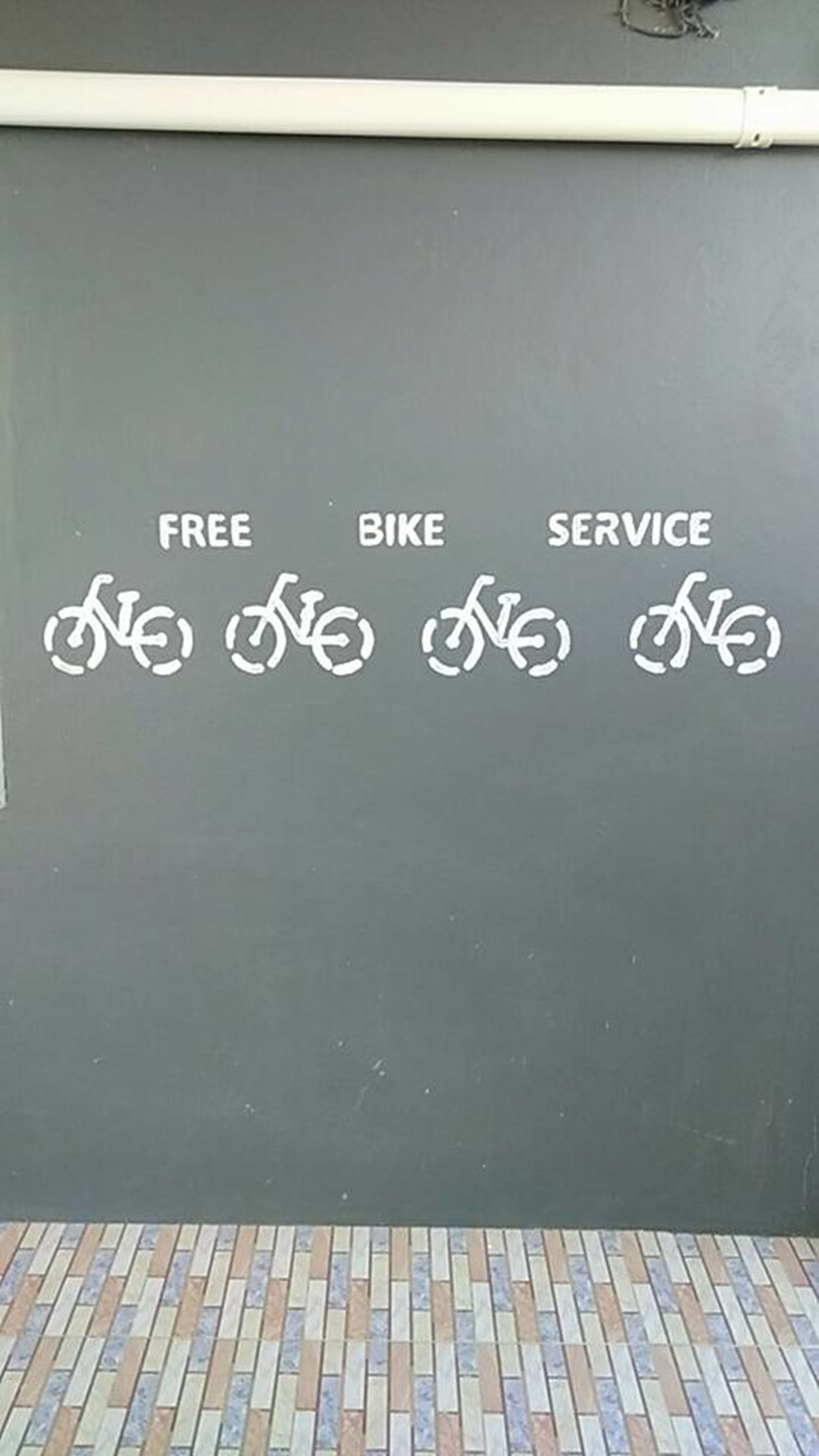 A wall with the words "FREE," "BIKE," and "SERVICE" and corresponding bicycle symbols.