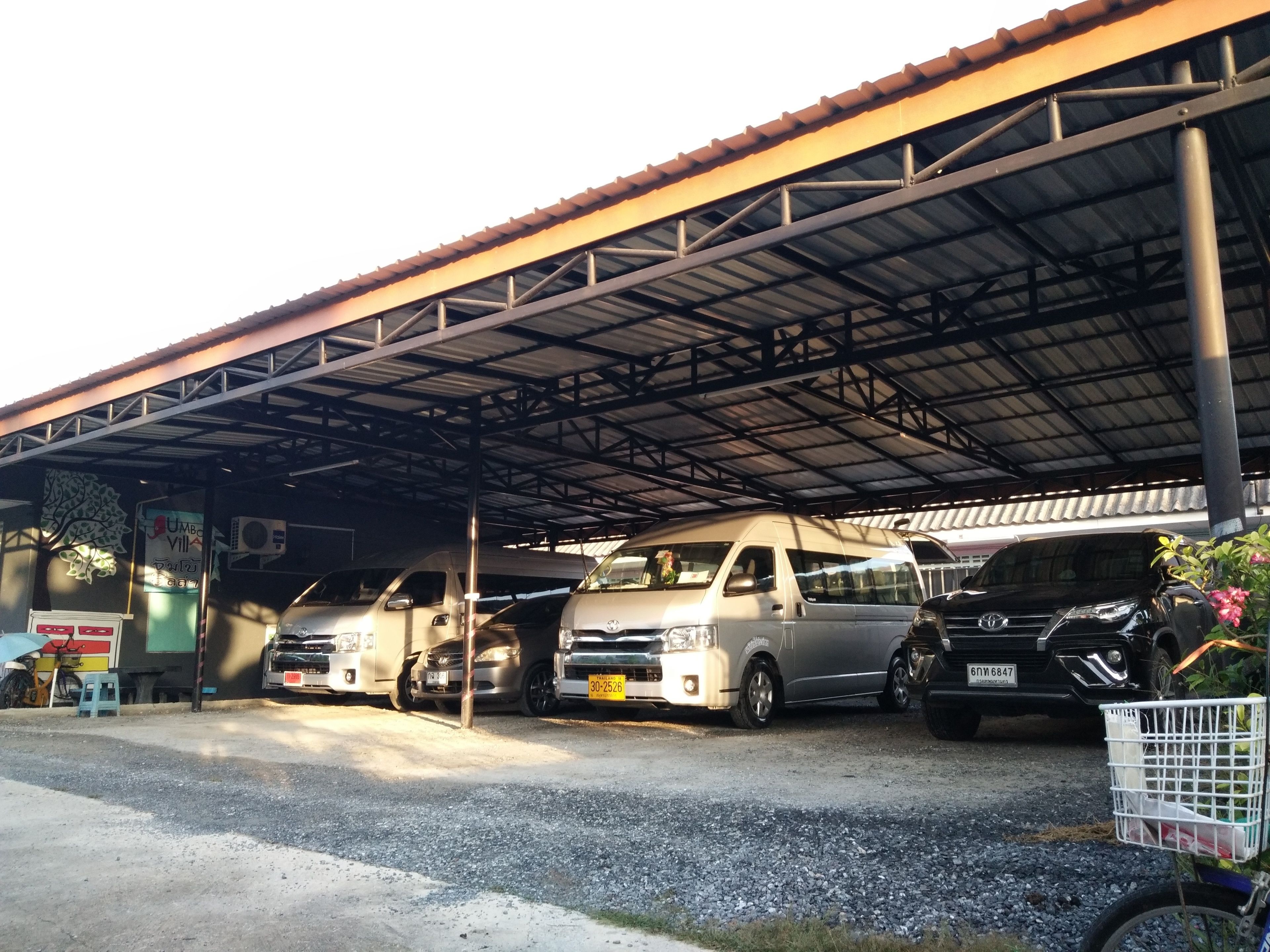 A covered parking area with several vehicles, including a Toyota SUV and a white van.