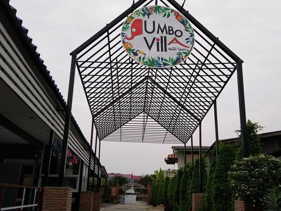 Un pasillo cubierto que conduce a un edificio con un letrero que dice 'UMBO VILL'.