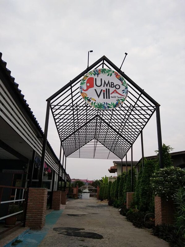 Un pasillo cubierto que conduce a un edificio con un letrero que dice 'UMBO VILL'.