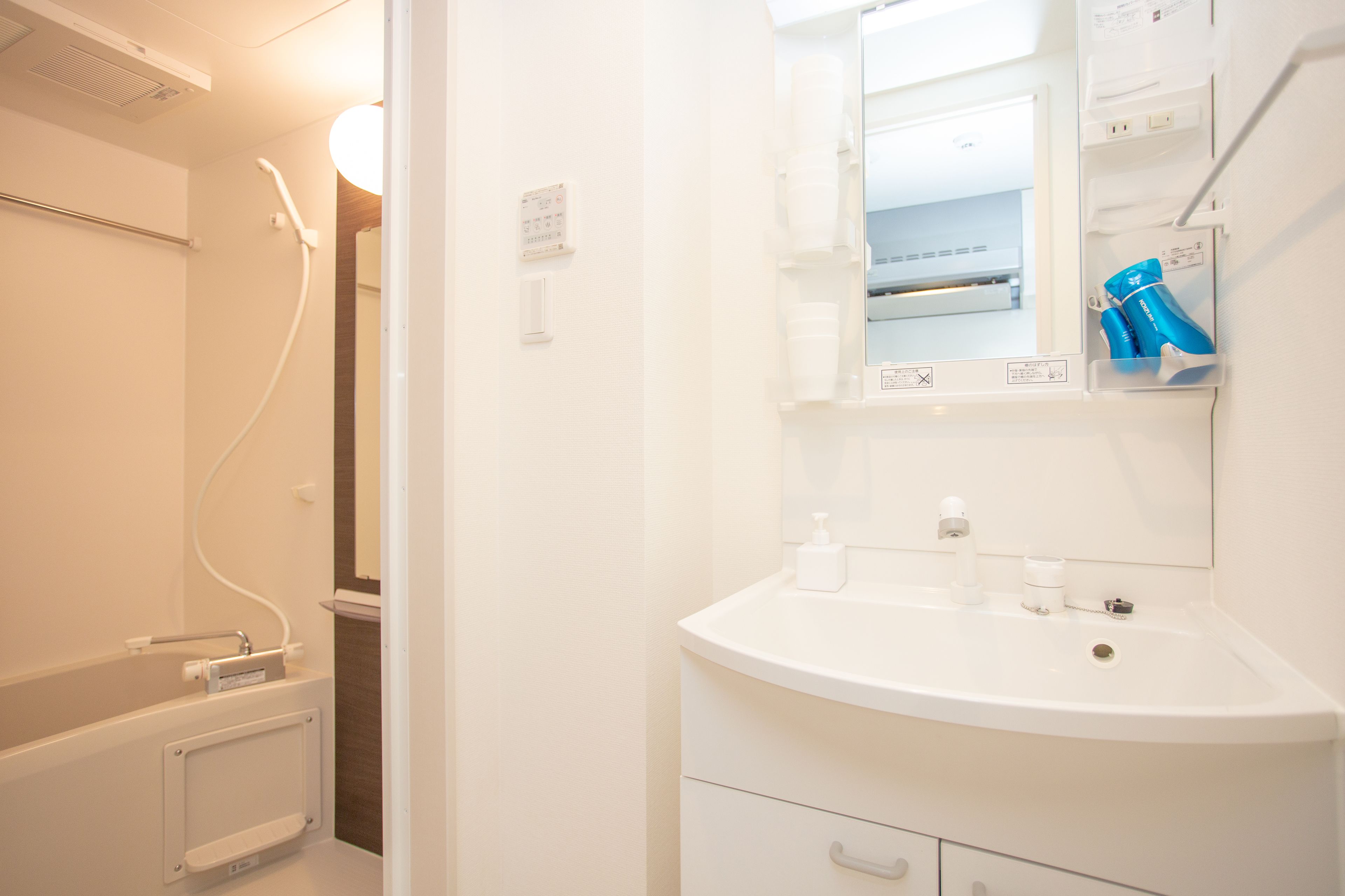 A modern bathroom with a white sink, mirror, and towel rack.