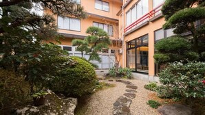 En traditionel japansk have med en sti af sten, omgivet af forskellige typer planter og træer.