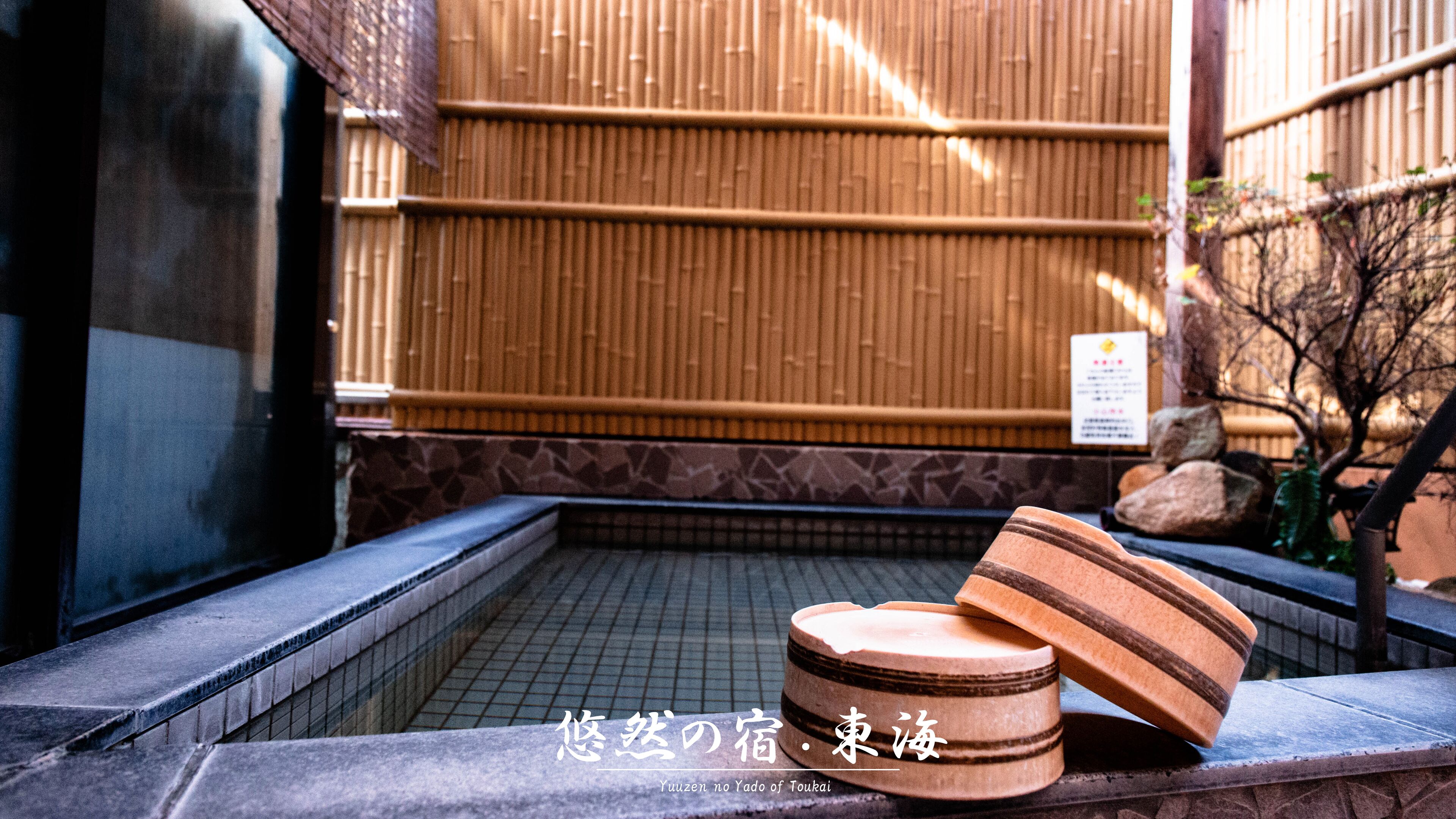 Un baño japonés tradicional con puertas correderas de madera y piso de baldosas.