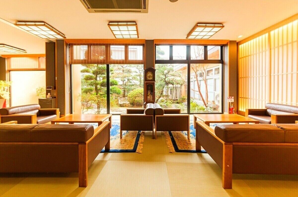 A traditional Japanese-style room with tatami flooring, a low table, and seating arrangements.