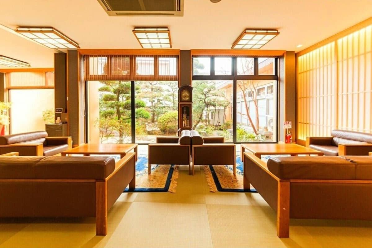Ein traditioneller japanischer Raum mit Tatami-Boden, einem niedrigen Tisch und Sitzgelegenheiten.