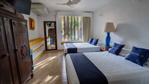 Una habitación de hotel con dos camas, televisión, ventilador de techo, ventana con cortinas y armario de madera.