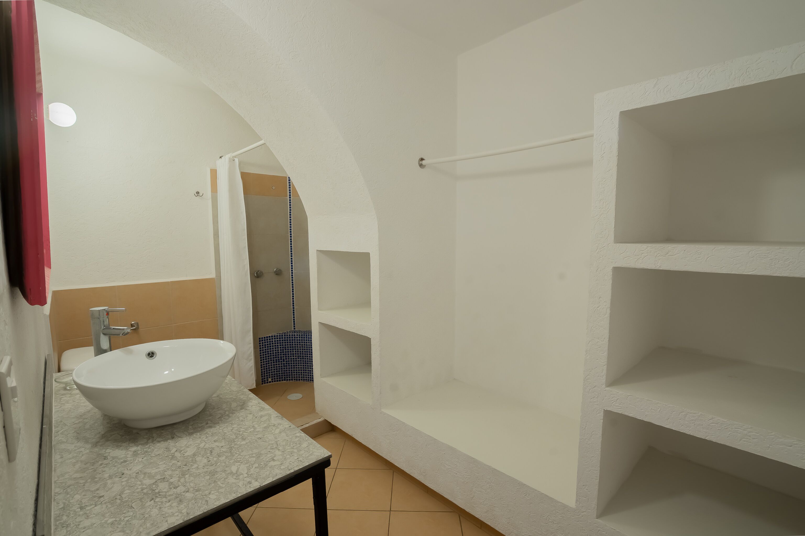 A bathroom with a white sink, a mirror, and a shower area.