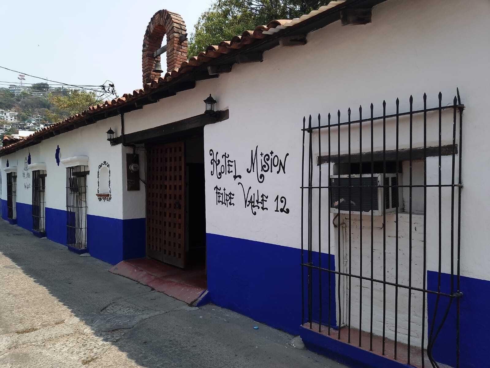 A building with a sign reading "Hotel Mission Valle 12" and a barred entrance.