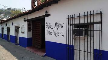 A building with a sign reading "Hotel Mission Valle 12" and a barred entrance.