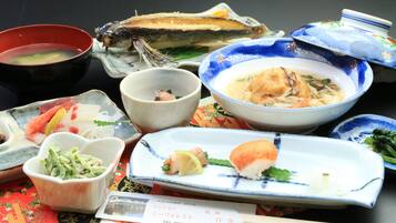 Une variété de plats japonais, notamment des sushis, des sashimis et des soupes, servis dans des assiettes et des bols traditionnels en céramique.