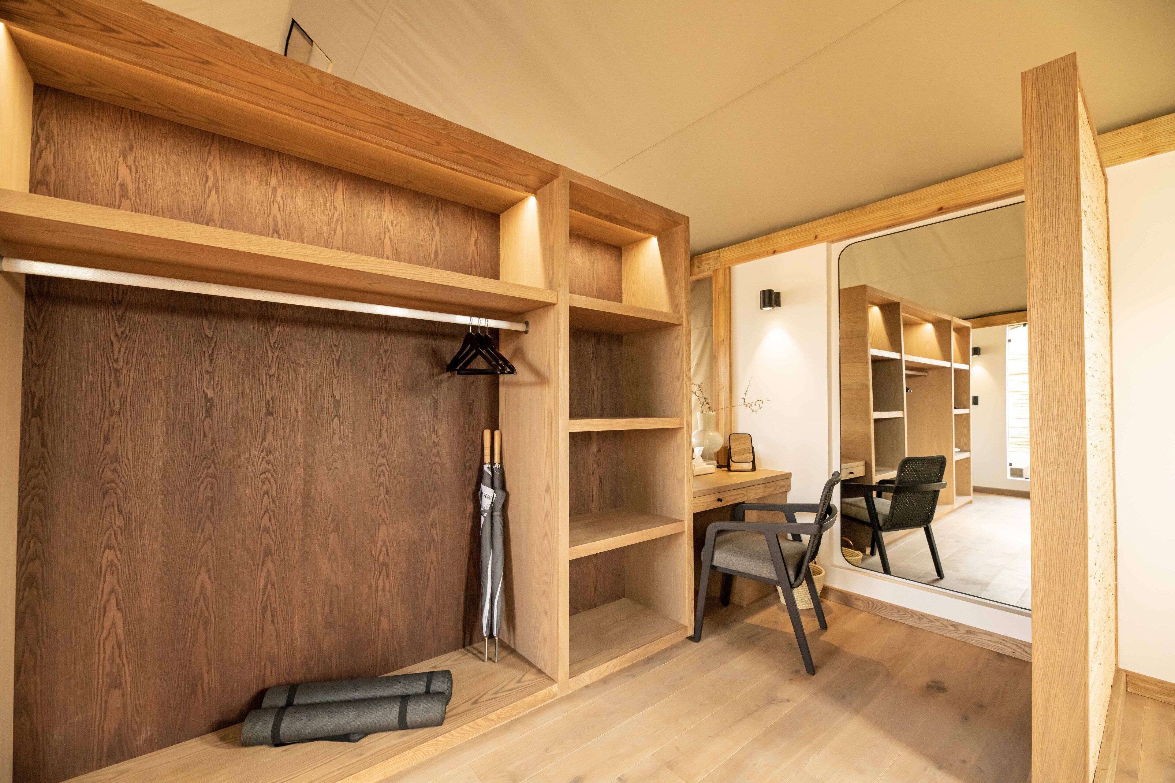 A room with wooden shelving, a desk, and a chair.