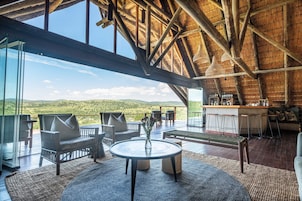 Un amplio espacio al aire libre con terraza de madera, asientos y una zona de bar.