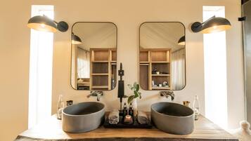 Ein Badezimmer mit zwei großen Waschbecken, einem Spiegel und einer Holzausstattung.