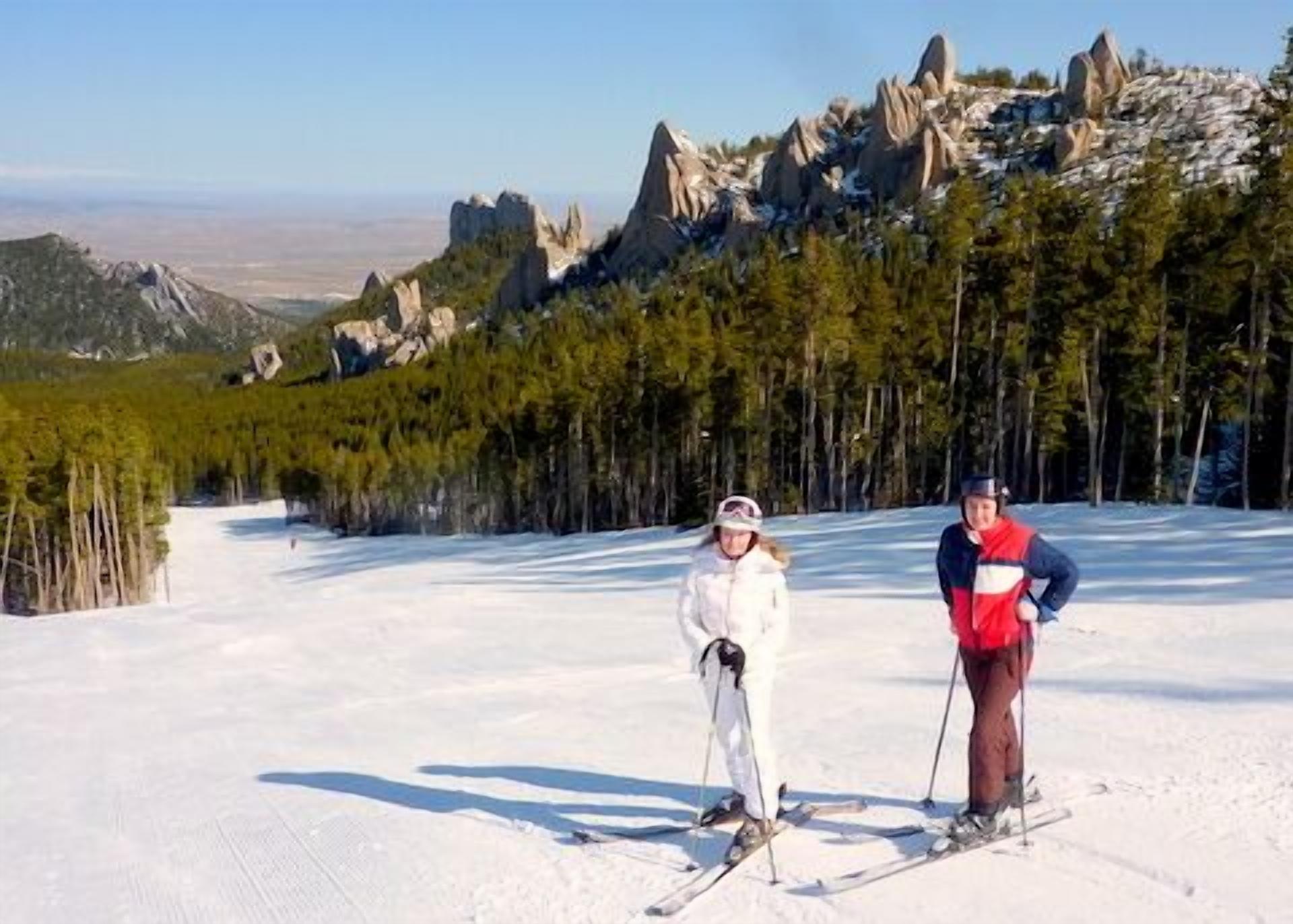 Ein verschneiter Ski-Hang mit zwei Skifahrern.