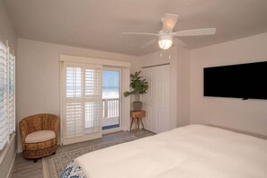 Relax in this serene bedroom with a large bed, ceiling fan, and flat-screen TV.