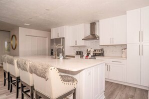 Enjoy cooking in this well-equipped kitchen with a central island, stainless steel appliances, and a large window above the sink.