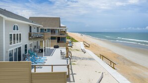 A beachfront property with a pool area, outdoor seating, and a view of the ocean. - 4 BR Oceanfront | Large Deck, Handicap Friendly, Fire Pit & Putting Green! (Ponte Vedra Beach)