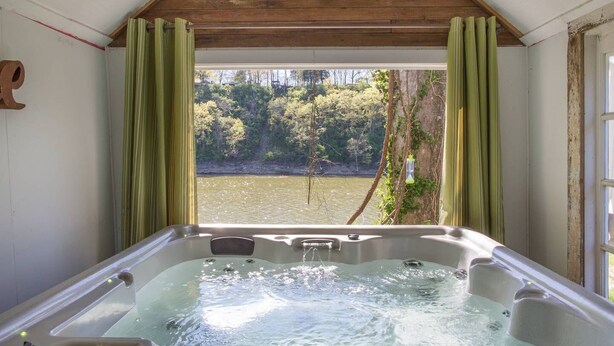Un bain à remous avec vue sur un lac et une forêt.