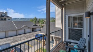 A balcony with a view of a parking area and distant mountains. - Immaculate PC condo - Extended Stay or Monthly rental, KING BED,  carport, W/D (Park City)
