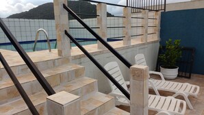 Outdoor steps leading to a pool area with a view of a mountain. - Guarujá-Enseada - 1 Bedroom Apartment with Pool (Guarujá)